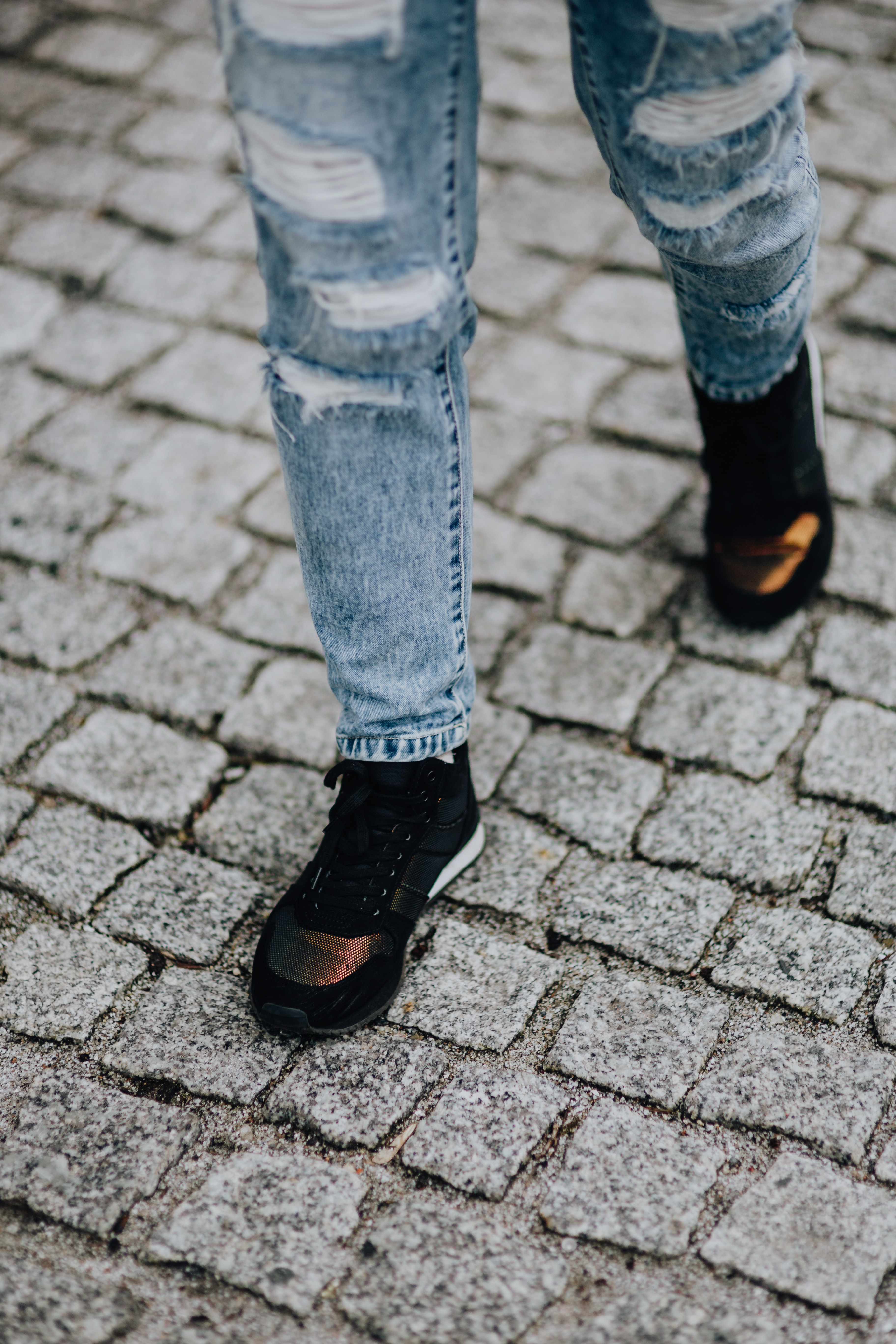 Woman in black sneakers and blue jeans