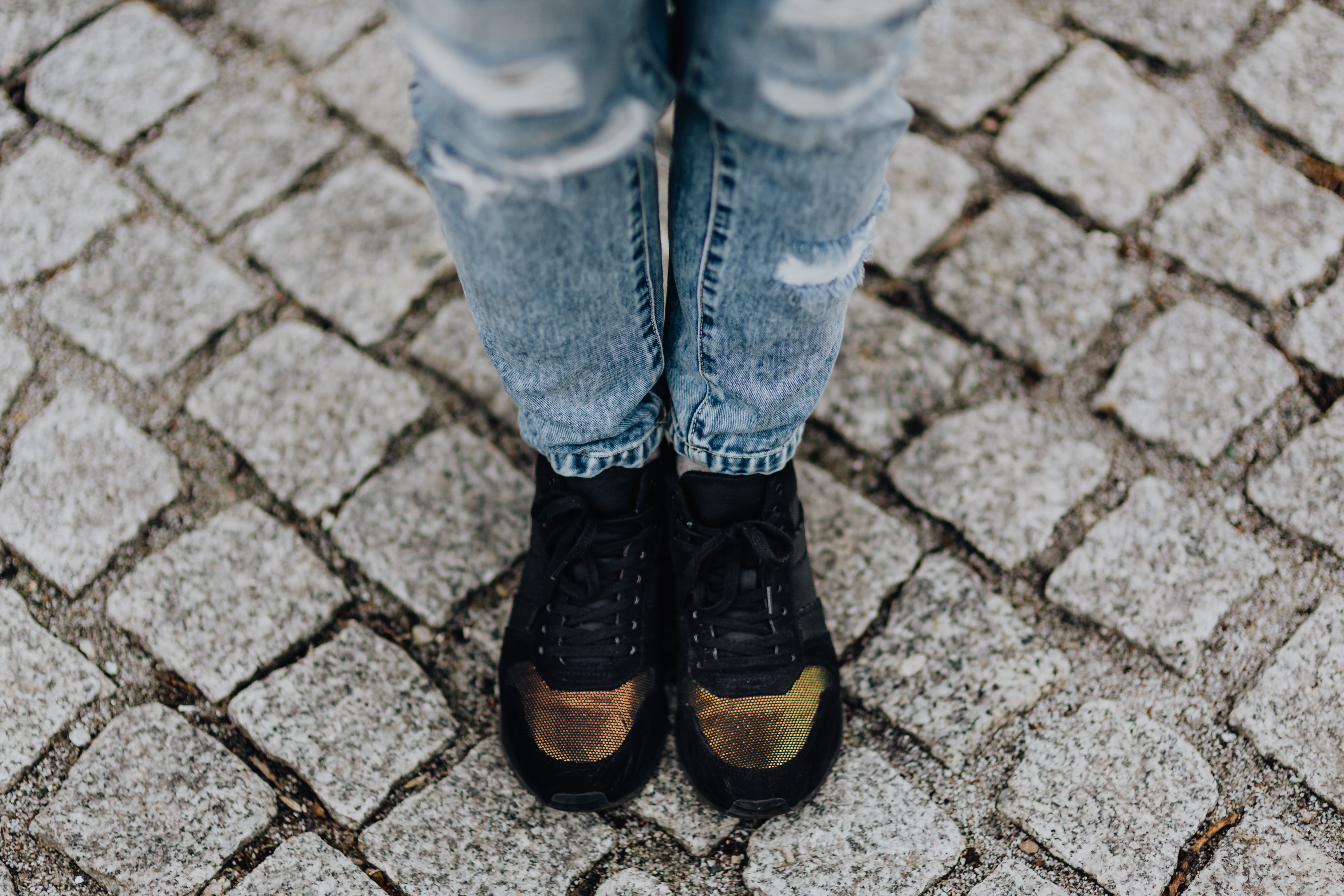 Woman in black sneakers and blue jeans