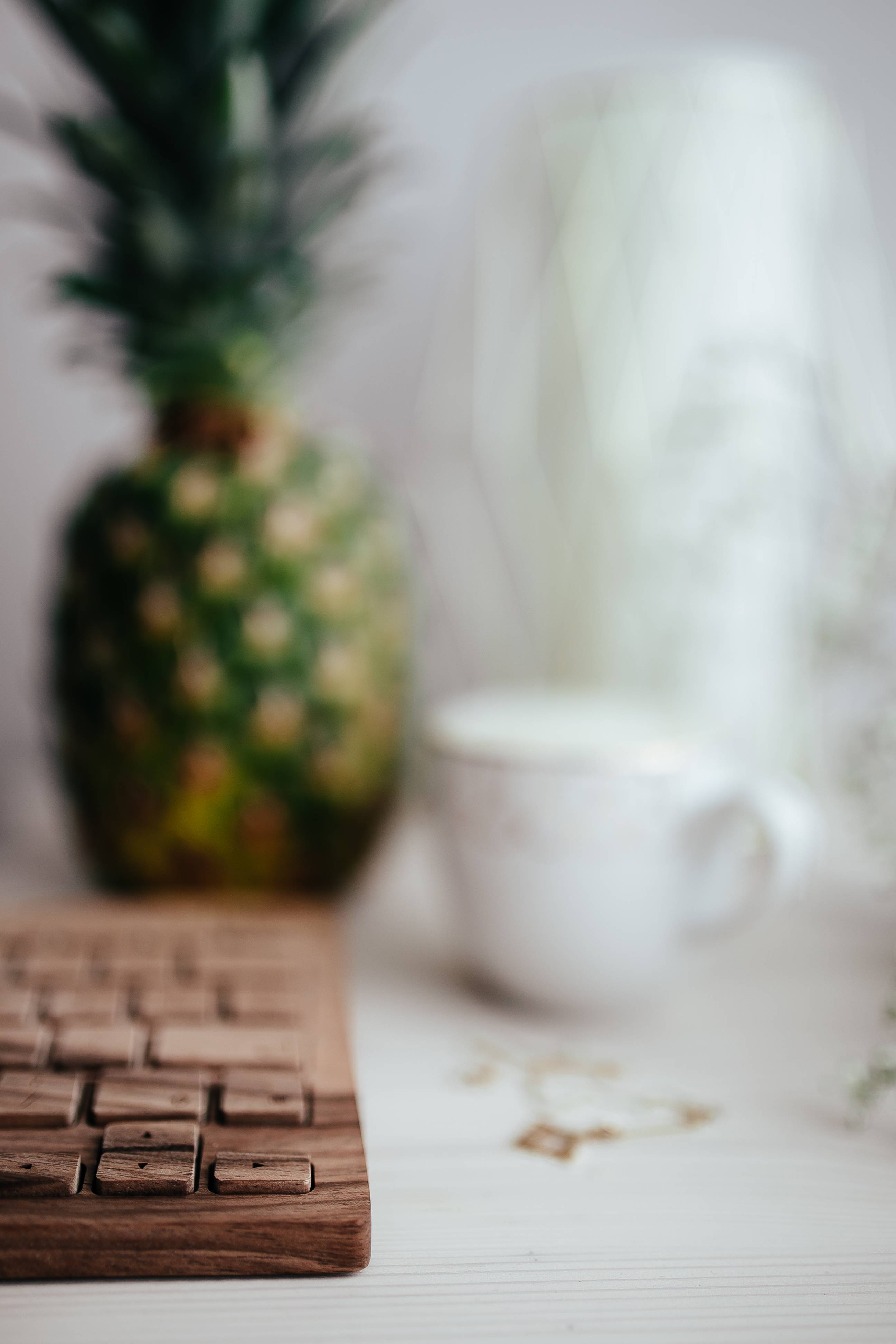 Wooden keyboard, coffee and pineapple