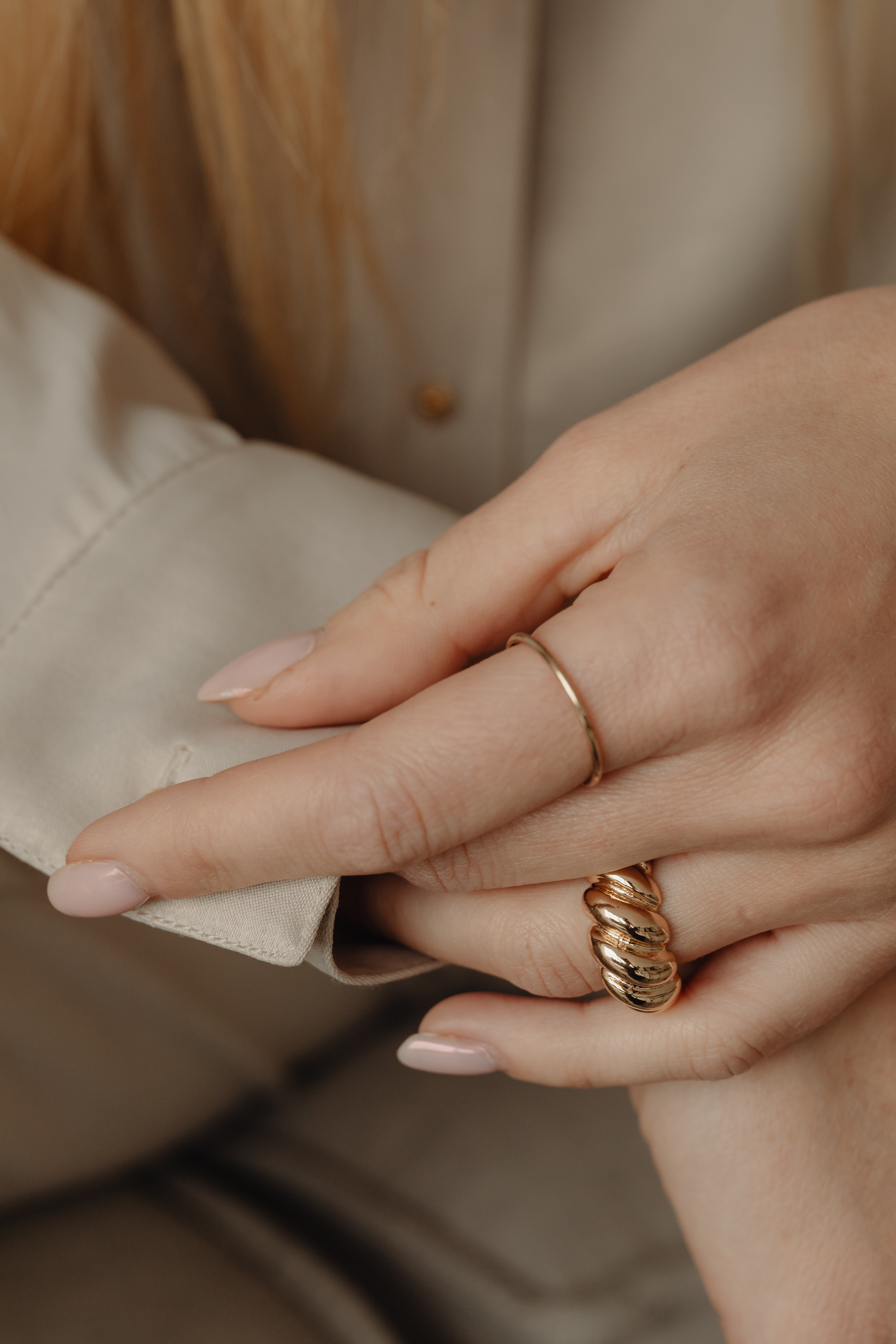 Details of gold jewelry - beautiful woman wearing a tan silk shirt