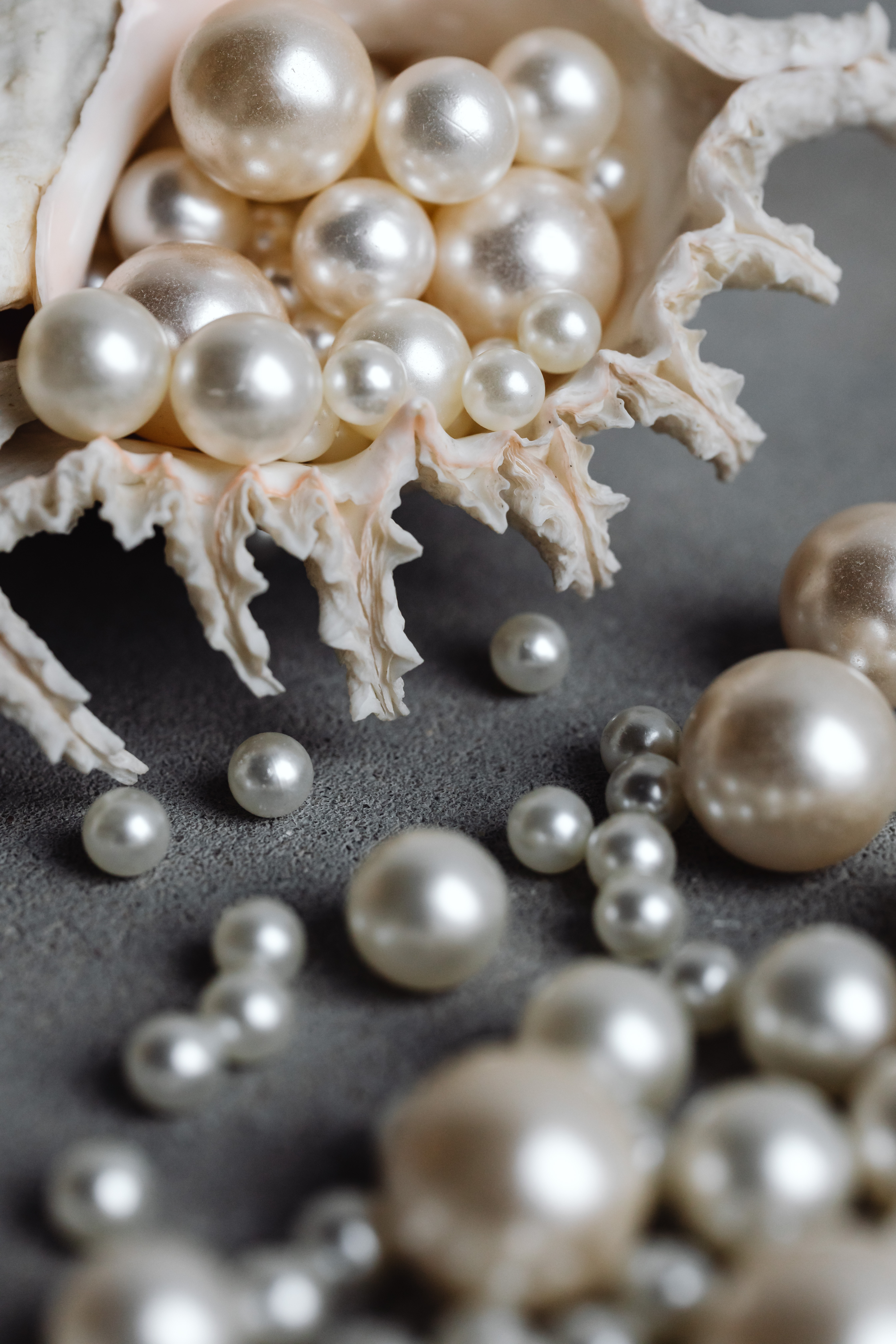 A large shell with pearls spilling out of it
