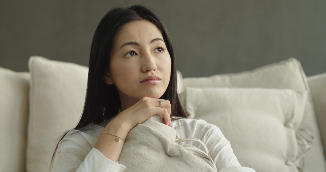 Woman Thinking while Hugging a Pillow