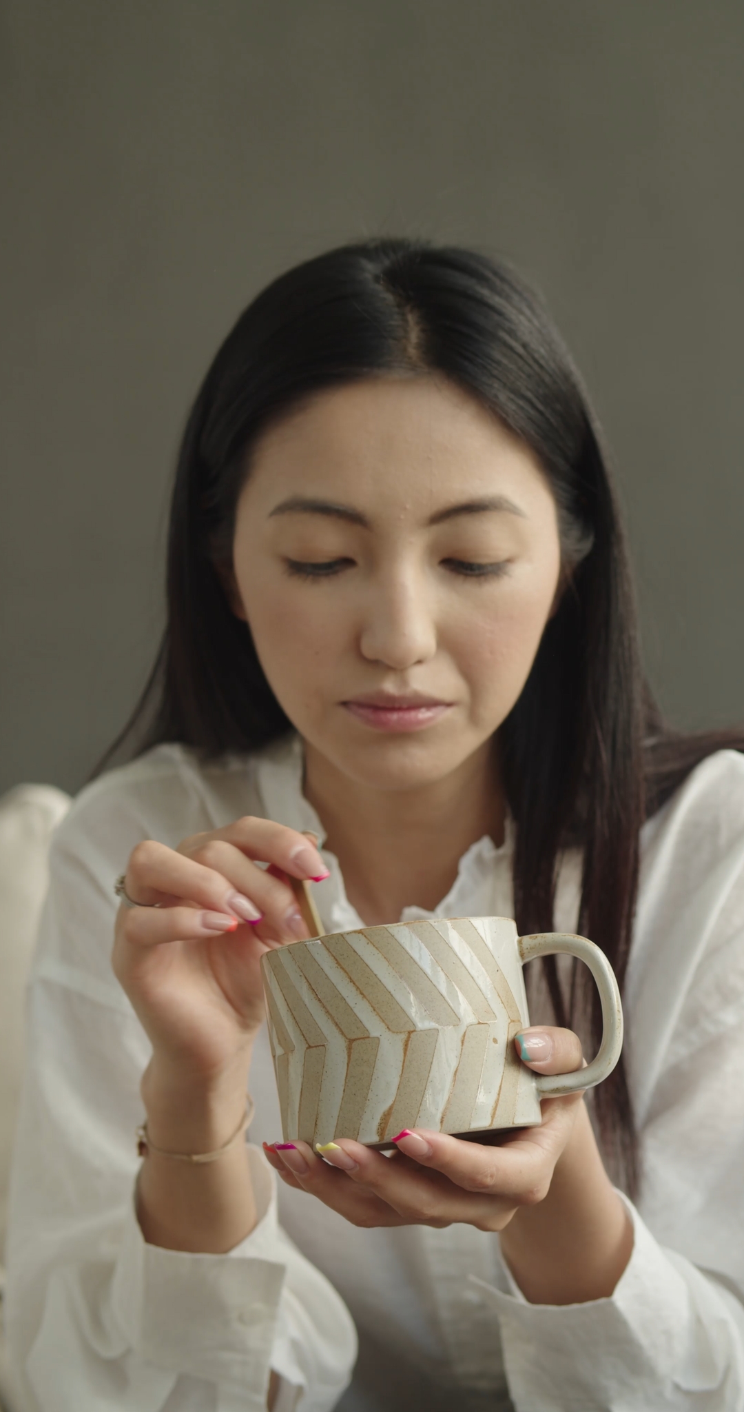 Woman Stirring and Cooling a Cup of Coffee