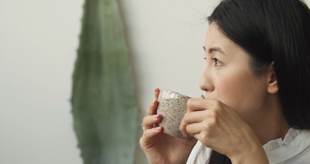 Close-Up of a Thoughtful Woman Enjoying a Cup of Coffee