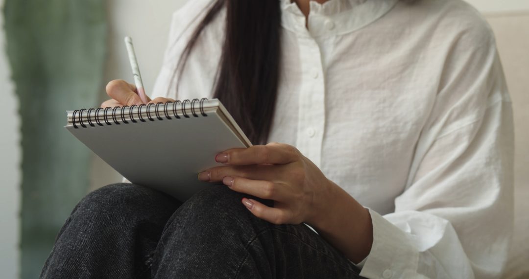 Close-up on a Woman Taking and Holding a Notebook