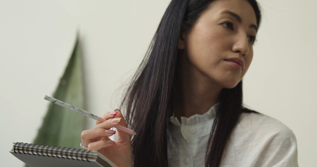 Woman Working, Thinking, Holding a Pencil and a Notebook