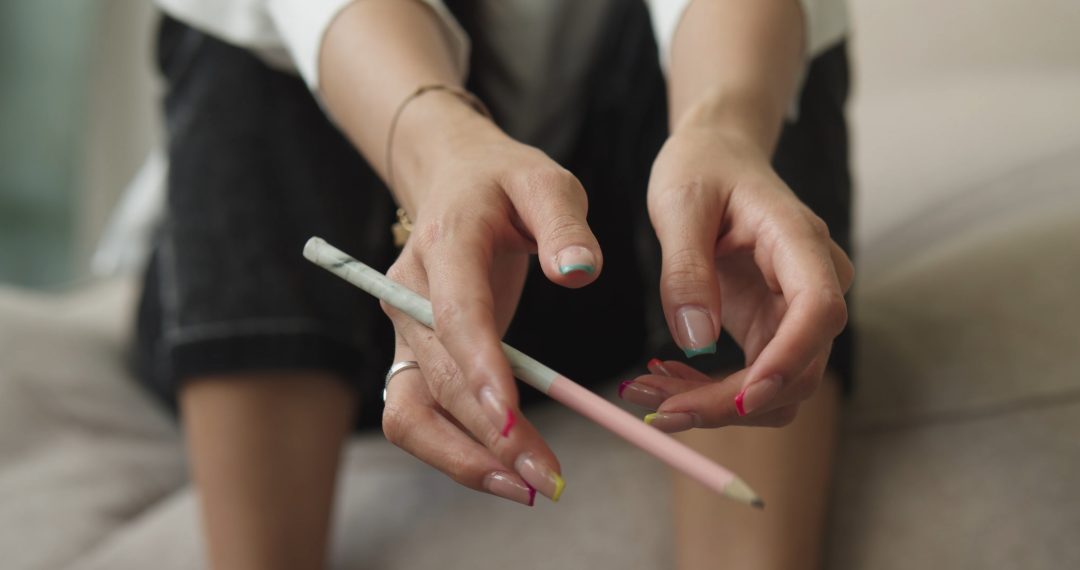 Close Up on Hands Holding a Pencil