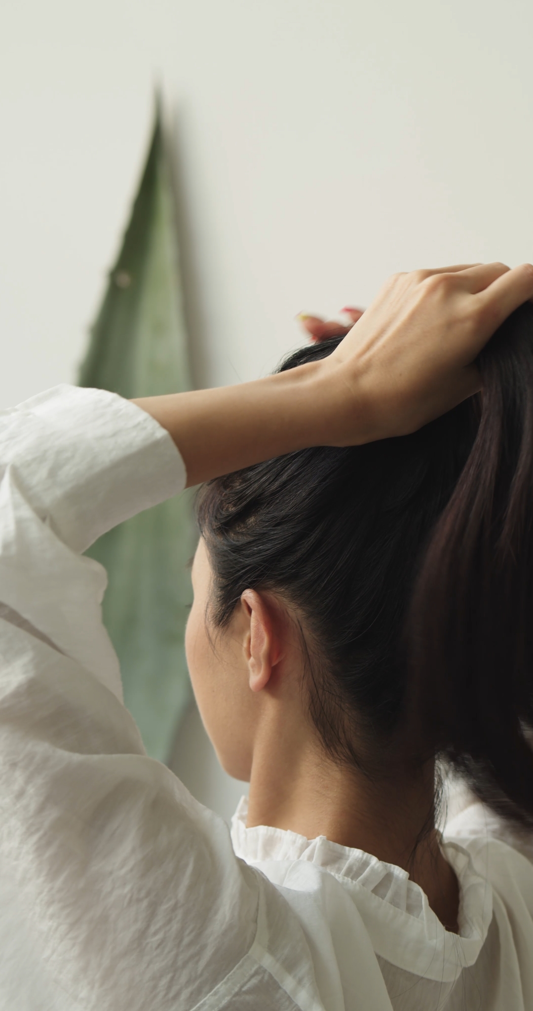 Woman Tying Hair Making a Ponytail