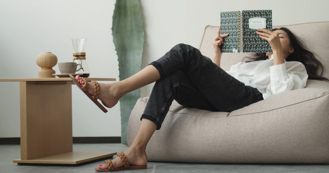 Woman Reading Notes While Sitting on a Chair, Rocking her Foot in the Air