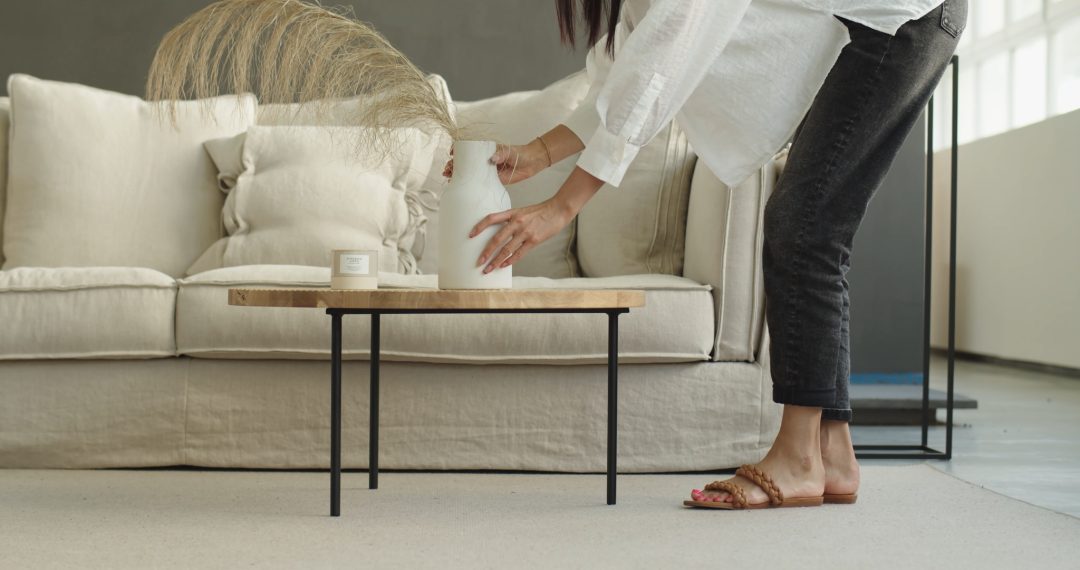 Woman in Sandals Placing Decorative Vase on the Table