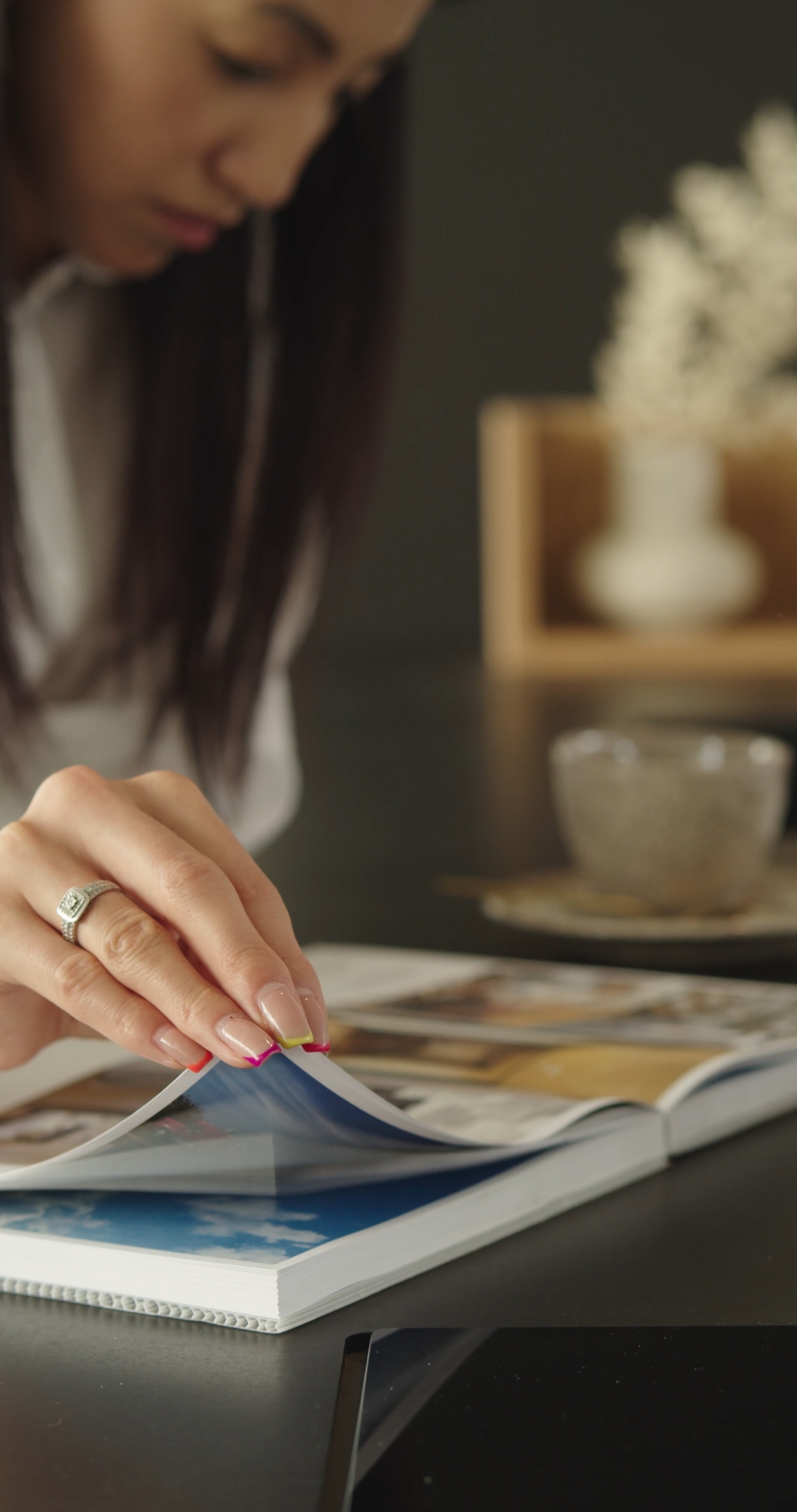 Woman Sitting at the Table Reading a Book