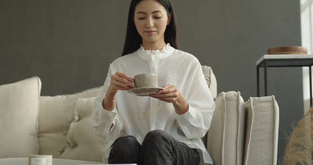 Woman Enjoys a Cup of Tea on The Couch