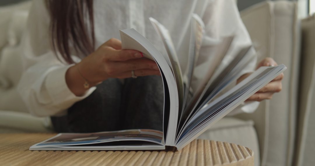 Woman at the Table Turning Book Pages