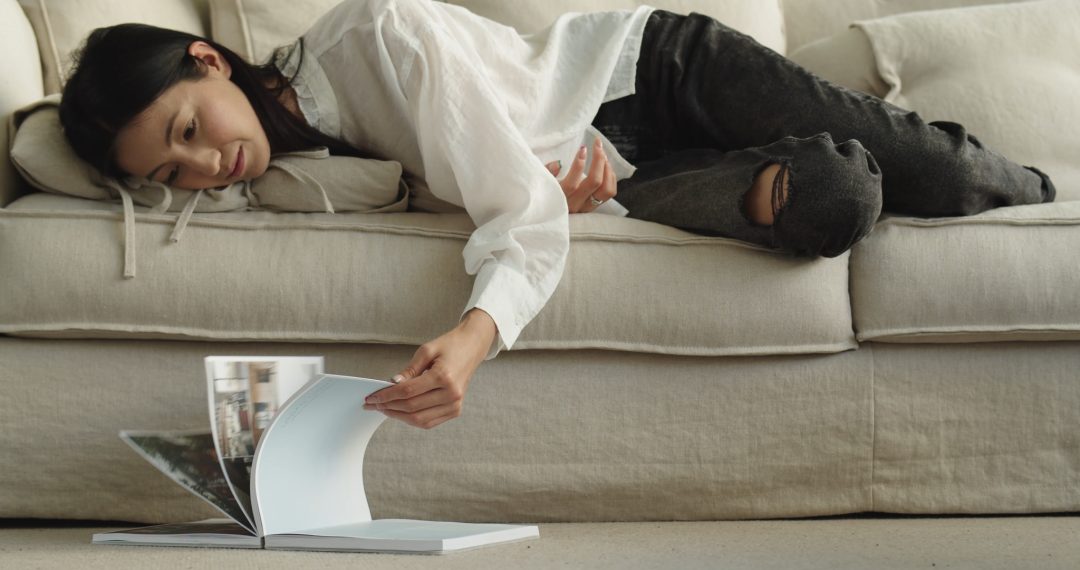 Woman Lies on the Couch Browsing Pages