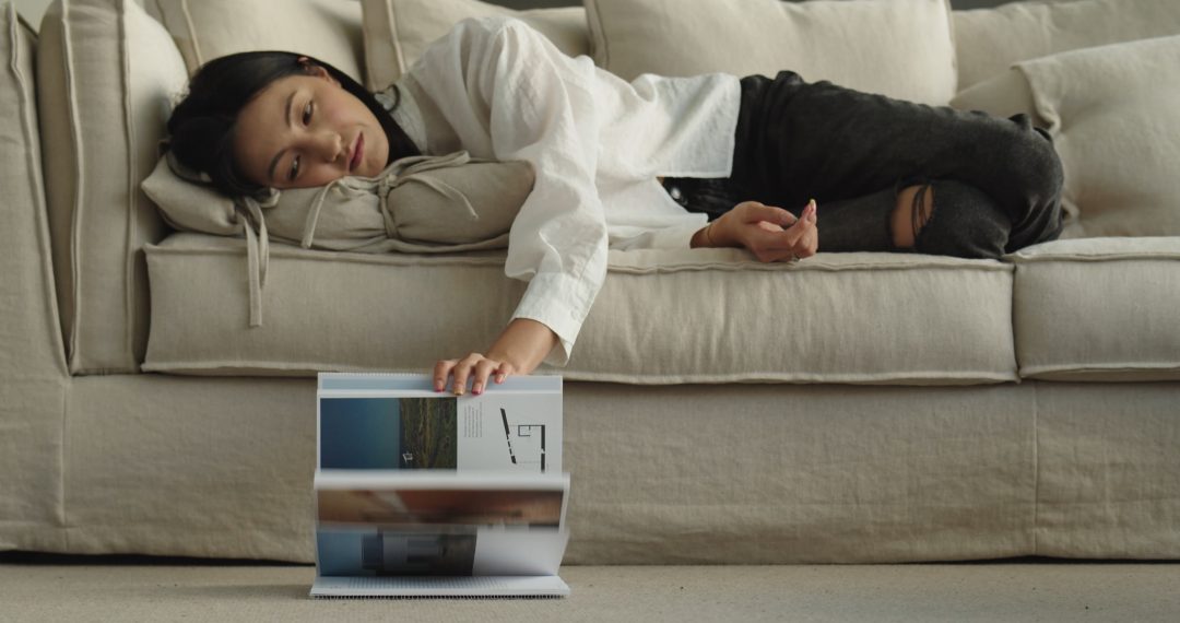 Woman Lying on the Couch Browsing Pages