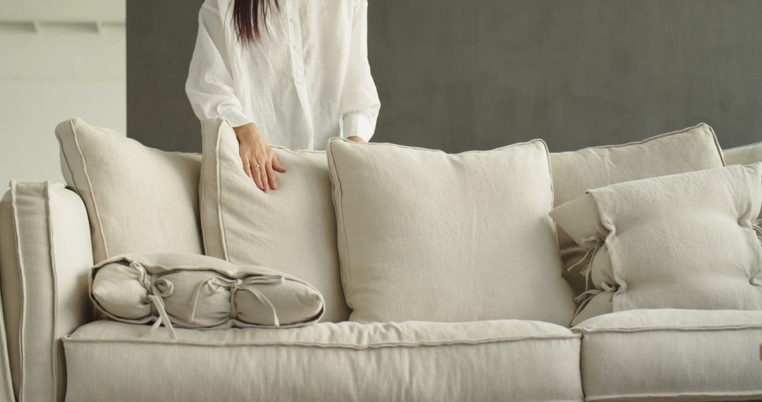 Woman Adjusting the Pillows on The Couch