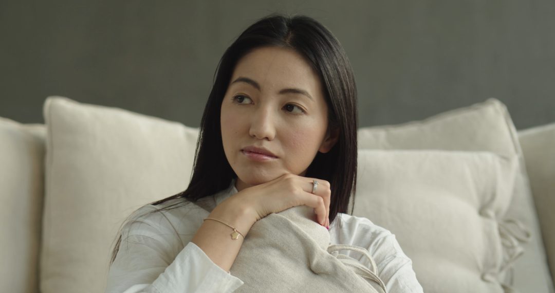 Woman Hugging a Pillow and Thinking With a Soft Smile on Her Face