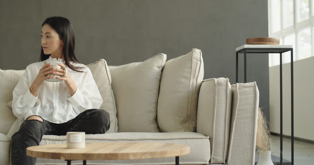 Woman Sitting on the Couch to Enjoy a Hot Cup of Coffee